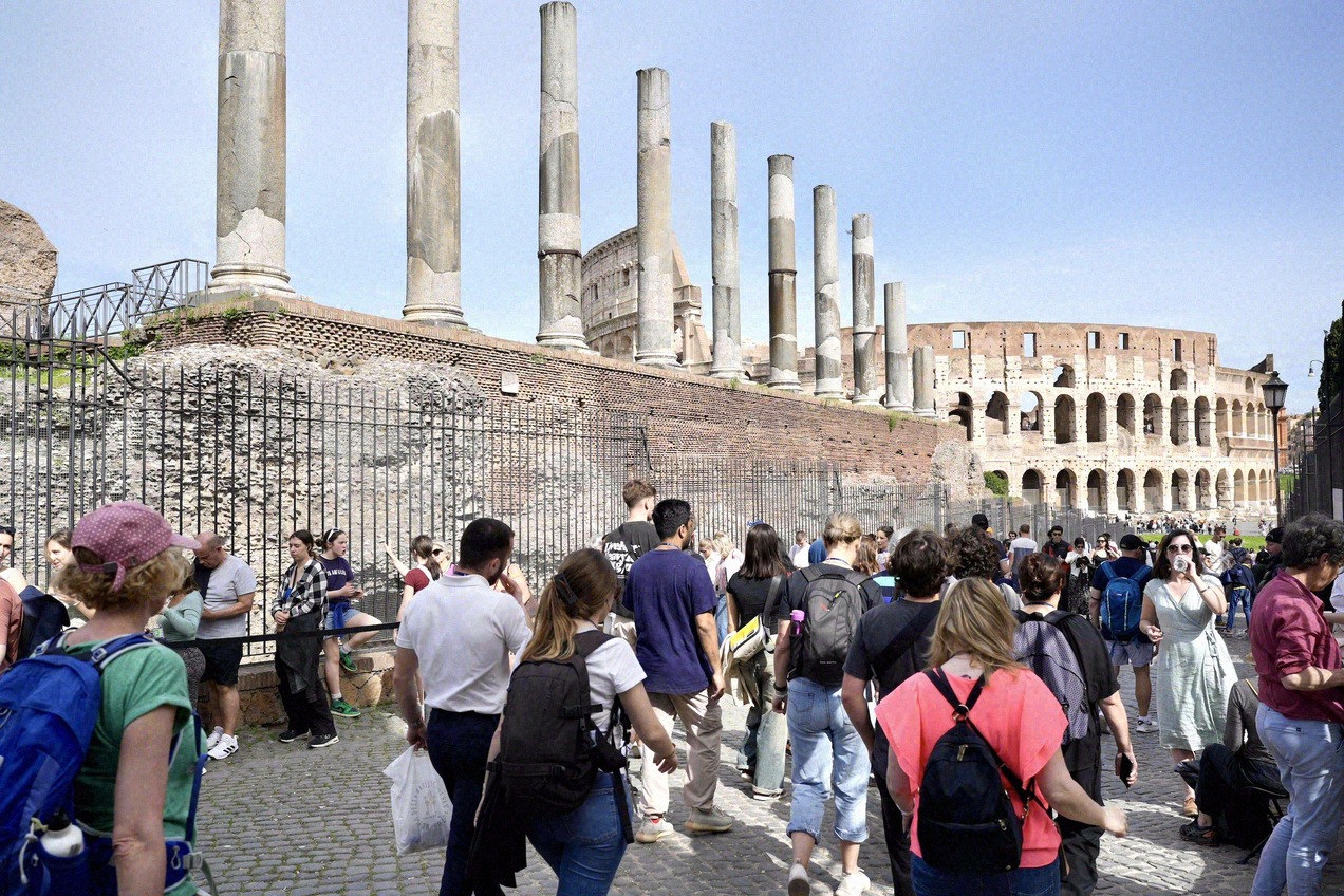 Columns and ruins of the Roman Forum with the Palatine Hill behind them.