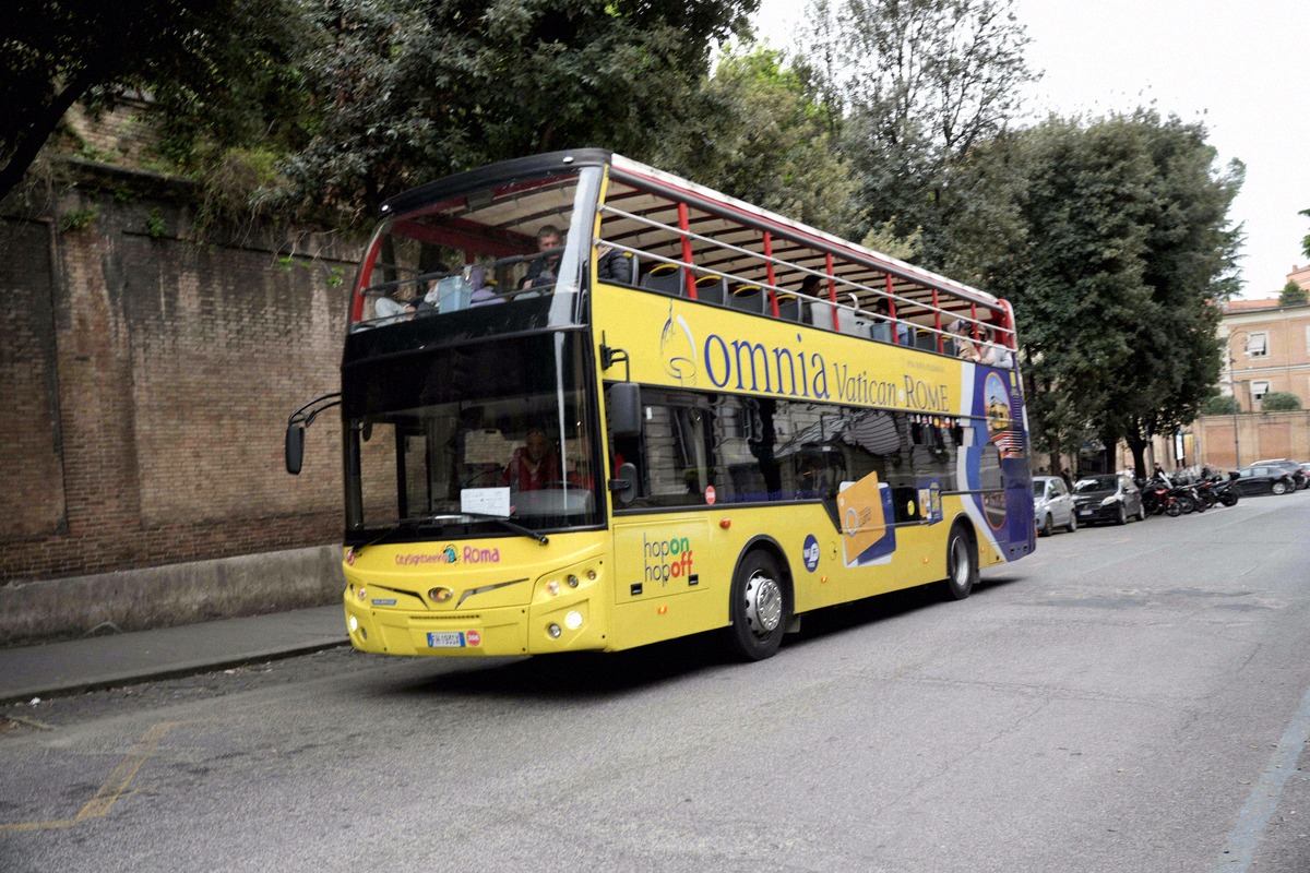 An open-top OMNIA Vatican & Rome sightseeing bus in Rome.