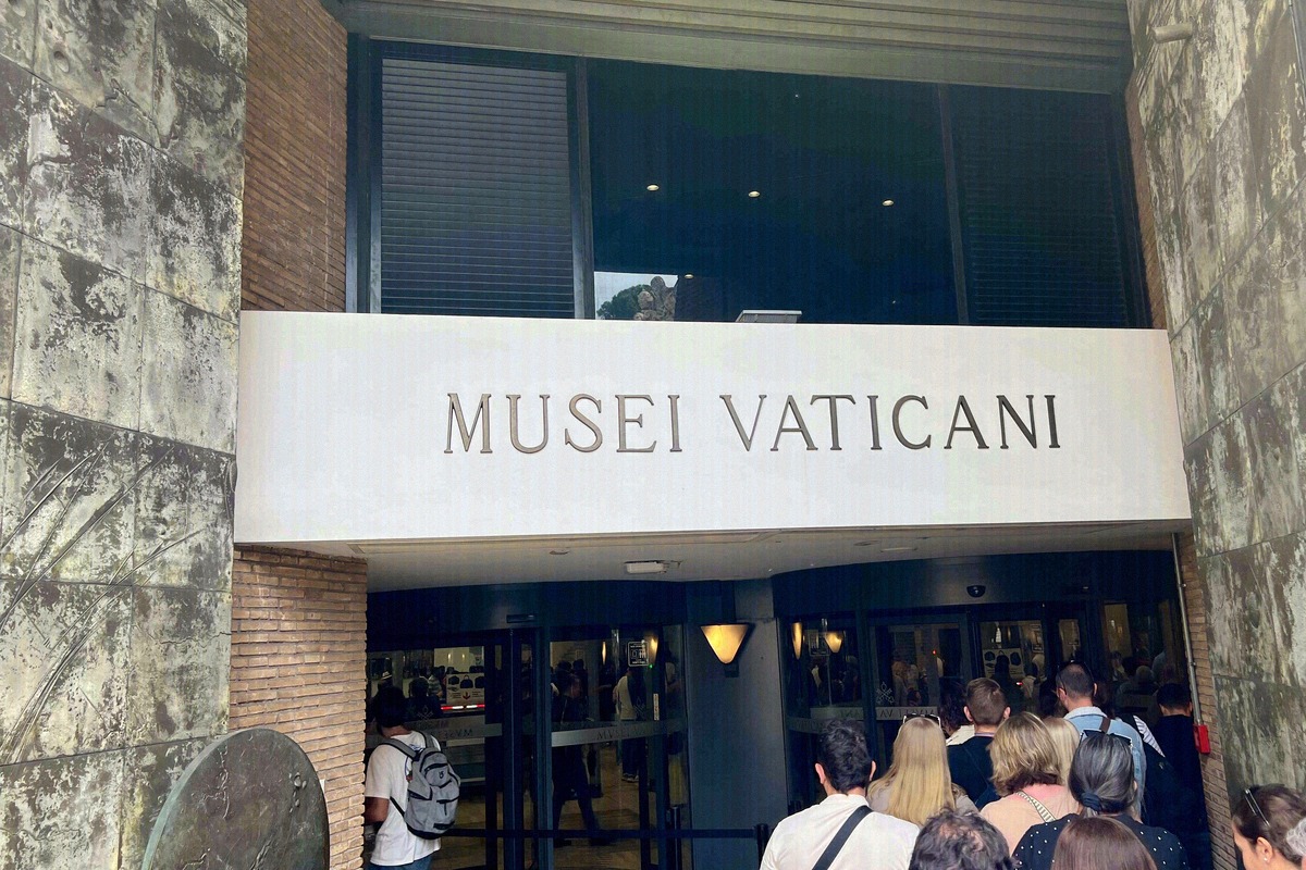 The entrance of the Vatican Museums on Viale Vaticano with visitors queuing under the stone portal.